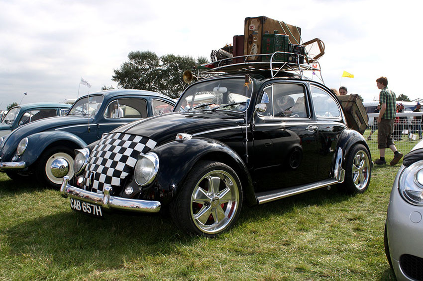 Ein VW Käfer mit vielen Koffern auf dem Dach des Autos